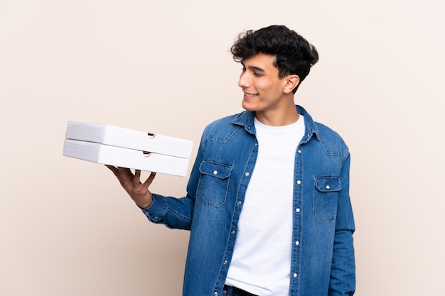 jonge man met pizza's dozen over geïsoleerde muur