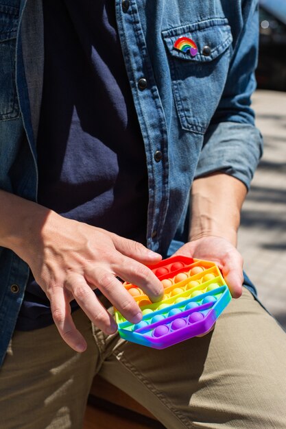 Jonge man met regenboog pop it fidget