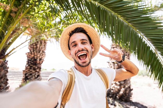 Jonge man met rugzak die selfie portret neemt op exotisch strand