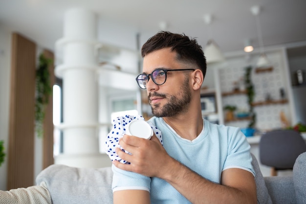 Jonge man met schouderpijn man met ijszak op pijnlijke schouder man hand die zijn schouder vasthoudt lijden aan schouderpijn lijden aan pijn in de hand thuis