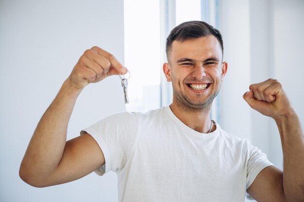 Jonge man met sleutels uit zijn nieuwe appartement