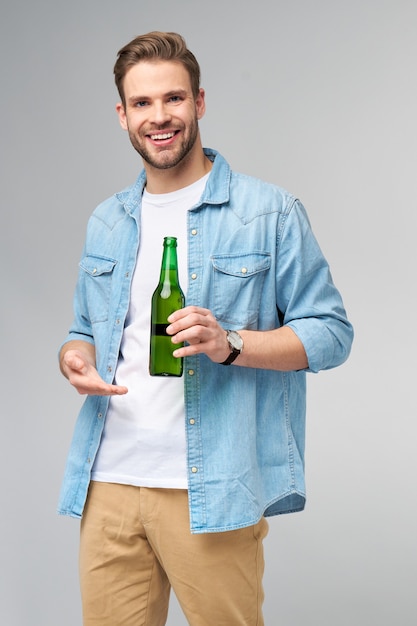 Jonge Man met spijkerbroek shirt bedrijf Fles bier staan