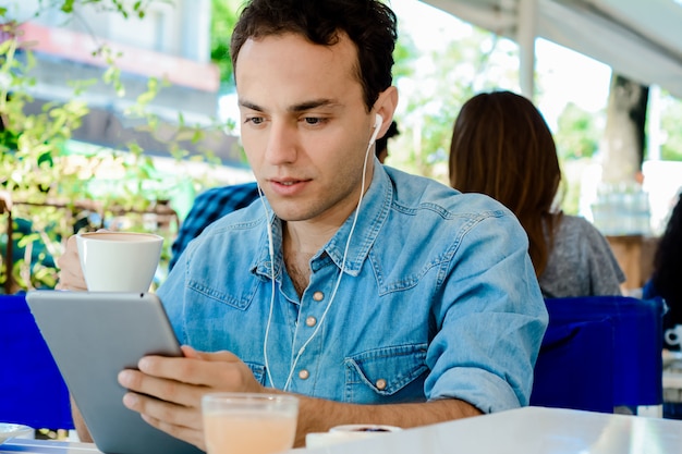 Jonge man met tablet in koffie winkel