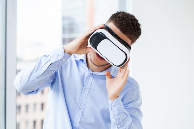 Jonge man met virtual reality bril in moderne coworking studio