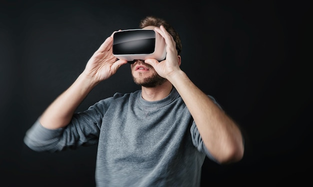 Jonge man met Virtual Reality-bril Vr-headset op zwarte achtergrond