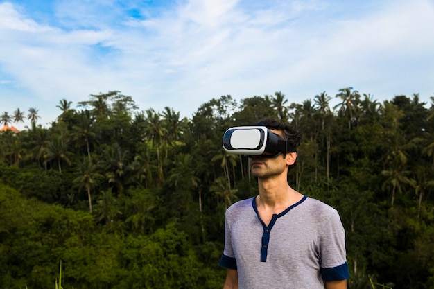 Jonge man met VR-bril in het tropische bos