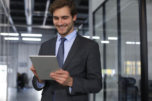 Jonge man met zijn tablet op kantoor.