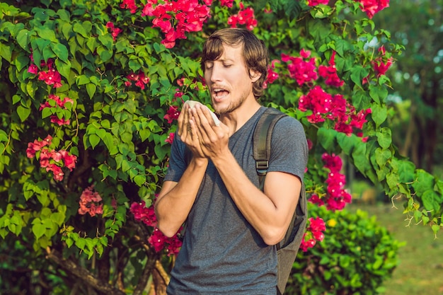 Jonge man niest vanwege een allergie voor pollen.