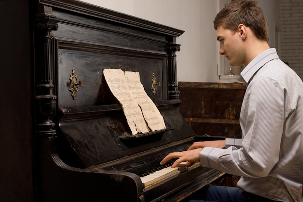 Jonge man oefent op een piano