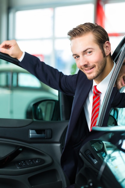 Jonge man of autodealer in autohandel drijven