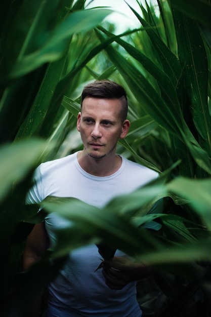 Jonge man omringd door planten