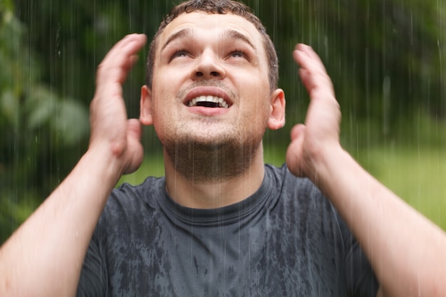 Jonge man onder de regen.