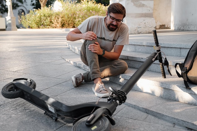 Foto jonge man ongeval met een elektrische scooter op straat