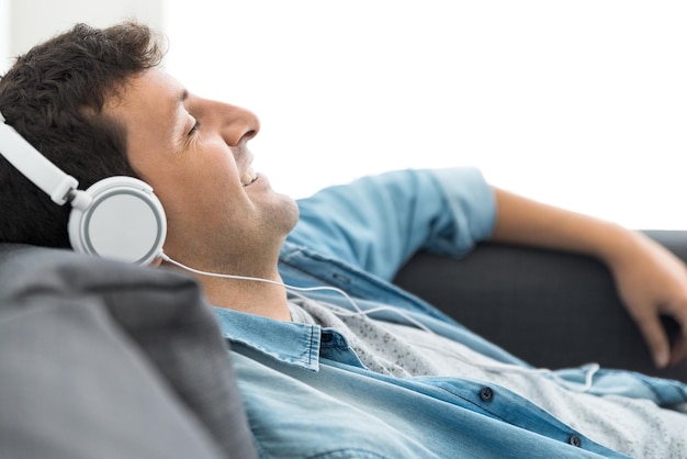 Jonge man ontspannen en lachend luisteren naar muziek