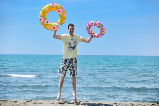 jonge man ontspannen op het strand bij zonsondergang