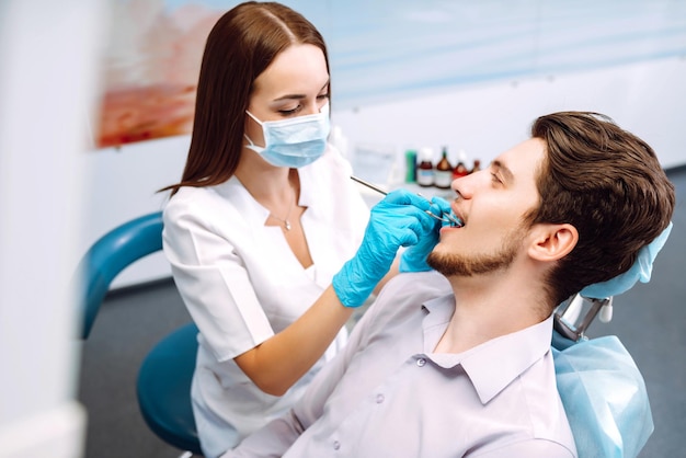 Jonge man op de tandartsstoel tijdens een tandheelkundige ingreep Overzicht van preventie van tandcariës