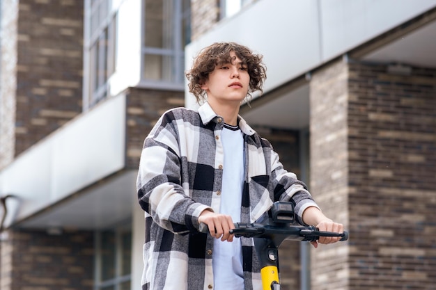 jonge man op een elektrische scooter rijdt de straat af