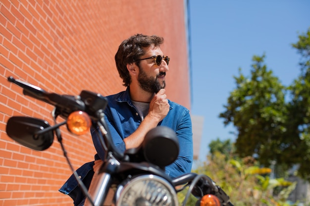 jonge man op een motorfiets denken