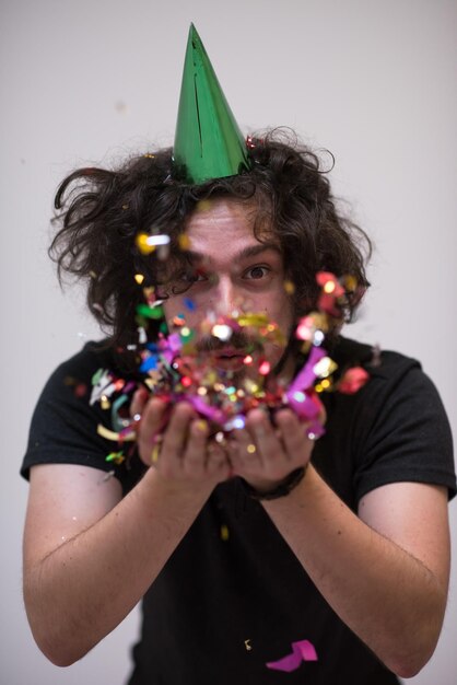 jonge man op feest viert nieuwjaar met vallende confetti