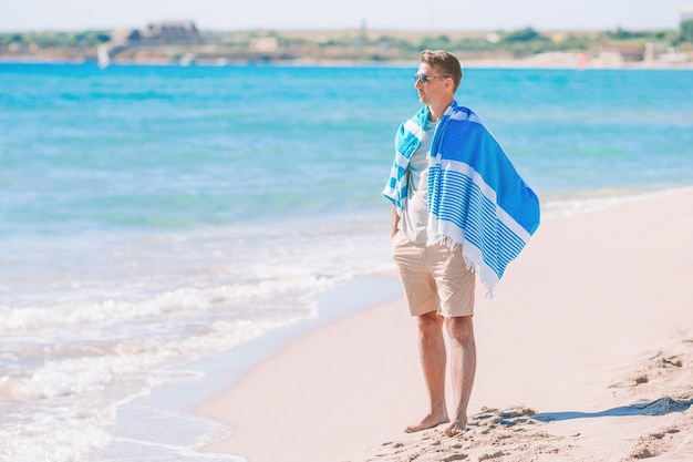 Jonge man op het witte strand op vakantie