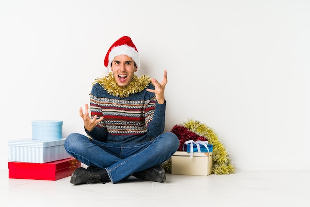 Jonge man op kerstdag persoon met de hand wijzen naar een shirt kopie ruimte, trots en zelfverzekerd