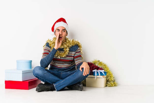 Jonge man op kerstdag punten met duim vinger weg, lachen en zorgeloos.