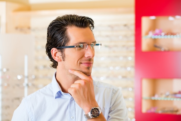 Jonge man op opticien met een bril