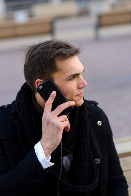 Jonge man op straat met mobiele telefoon