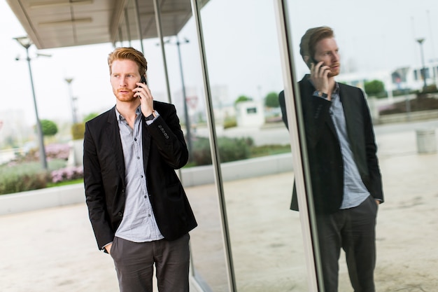 Foto jonge man op straat met mobiele telefoon