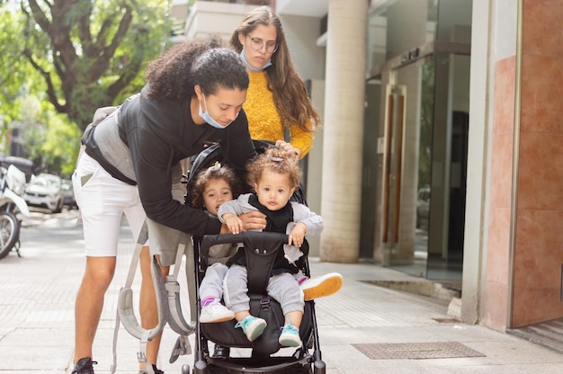 jonge man op straat met zijn gezin die zijn dochter uit de kinderwagen haalt