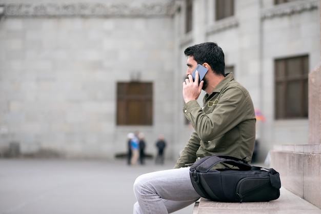 Jonge man op straat praten aan de telefoon