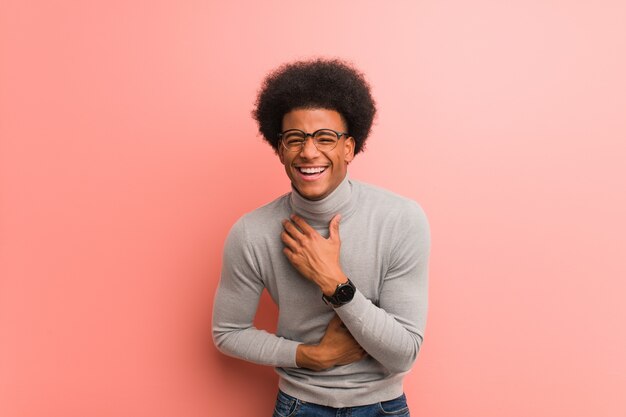 Foto jonge man over een roze muur lachen en plezier maken