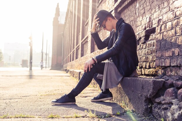 Jonge man poseren met een trendy outfit tegen een stedelijke achtergrond