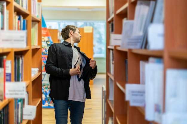 jonge man probeert boek uit de bibliotheek te stelen. kleptomanie b