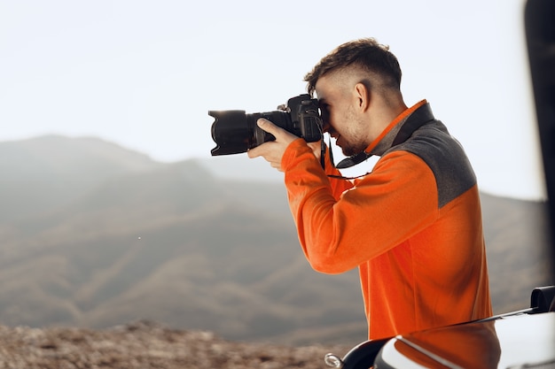 Jonge man reiziger fotograferen van bergen met professionele camera