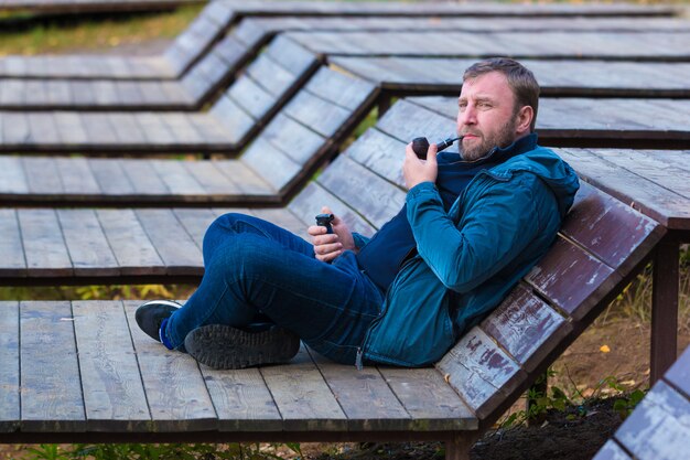 Jonge man rookpijp in park