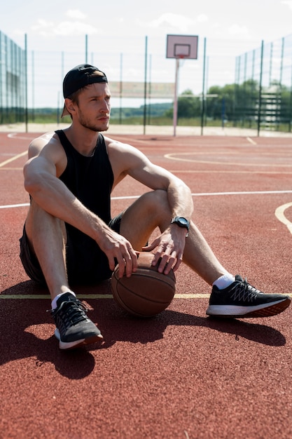 Jonge man rust in basketbalveld