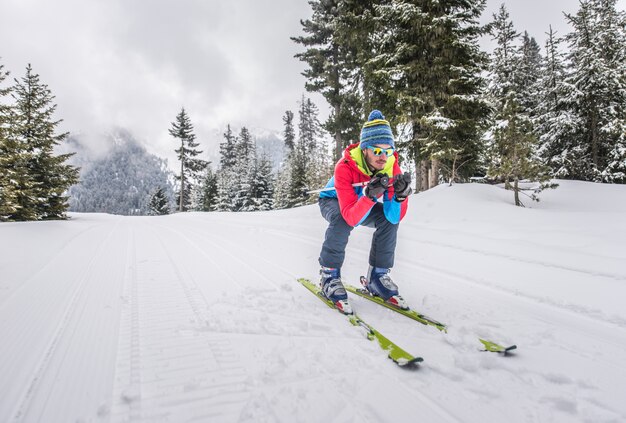 Jonge man skiën op de bergen buiten het spoor