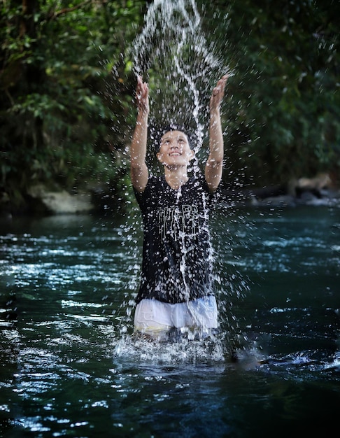 Foto jonge man spat water in een waterval