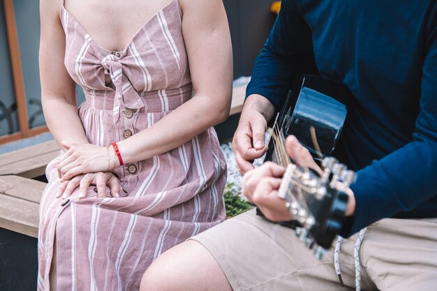 Jonge man speelt voor zijn jonge vrouw. concept van muziek in ons leven. prachtige momenten . levensstijl. hoge kwaliteit foto