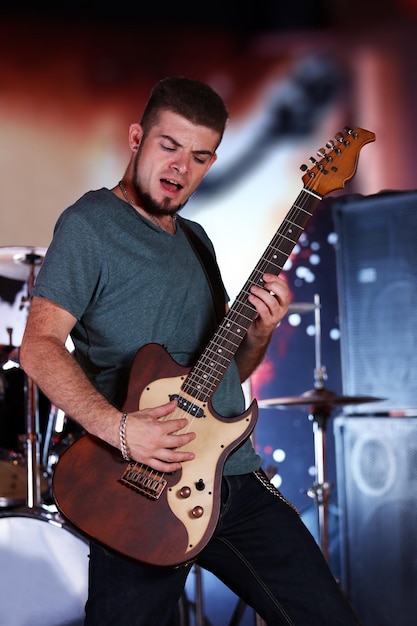 Jonge man spelen op elektrische gitaar in pub