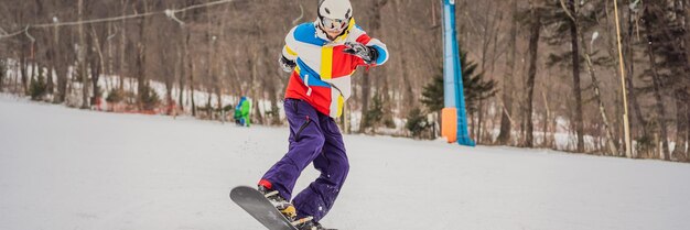 Foto jonge man springt met een snowboard in de bergen banner lang formaat