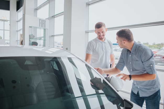 Jonge man staan voor witte auto