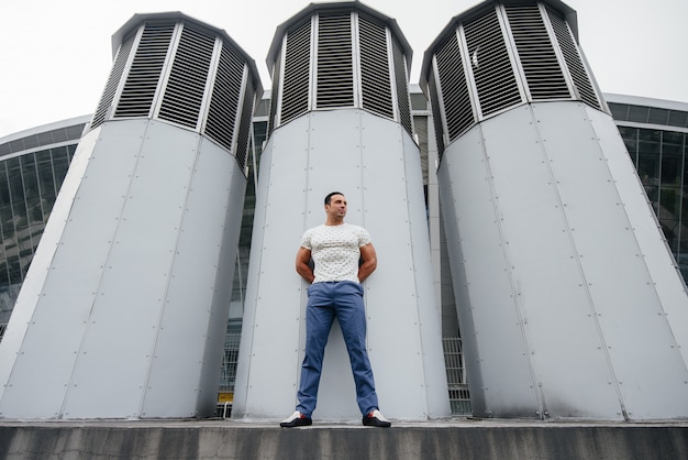 jonge man staat in de open lucht in de buurt van technische constructies.