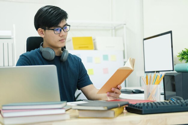 Jonge man studeert thuis achter de laptopcomputer