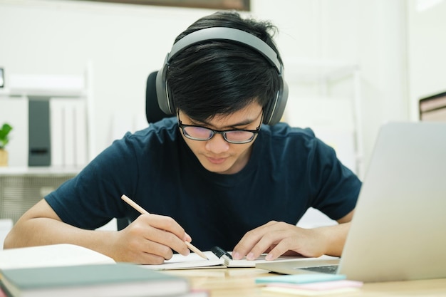 Jonge man studeert thuis achter de laptopcomputer