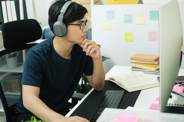 Jonge man studeert thuis achter de laptopcomputer