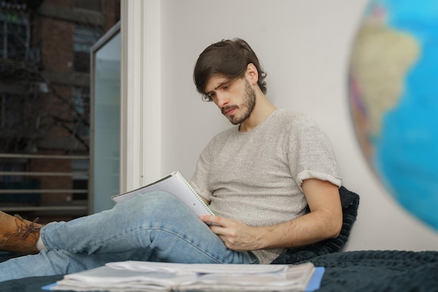 Jonge man studeren geconcentreerd in bed