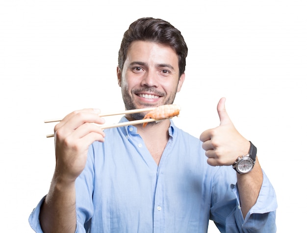 Jonge man sushi eten op witte achtergrond