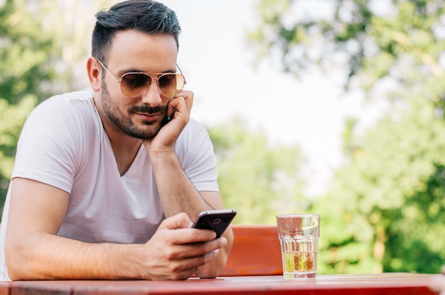 Foto jonge man texting in het café